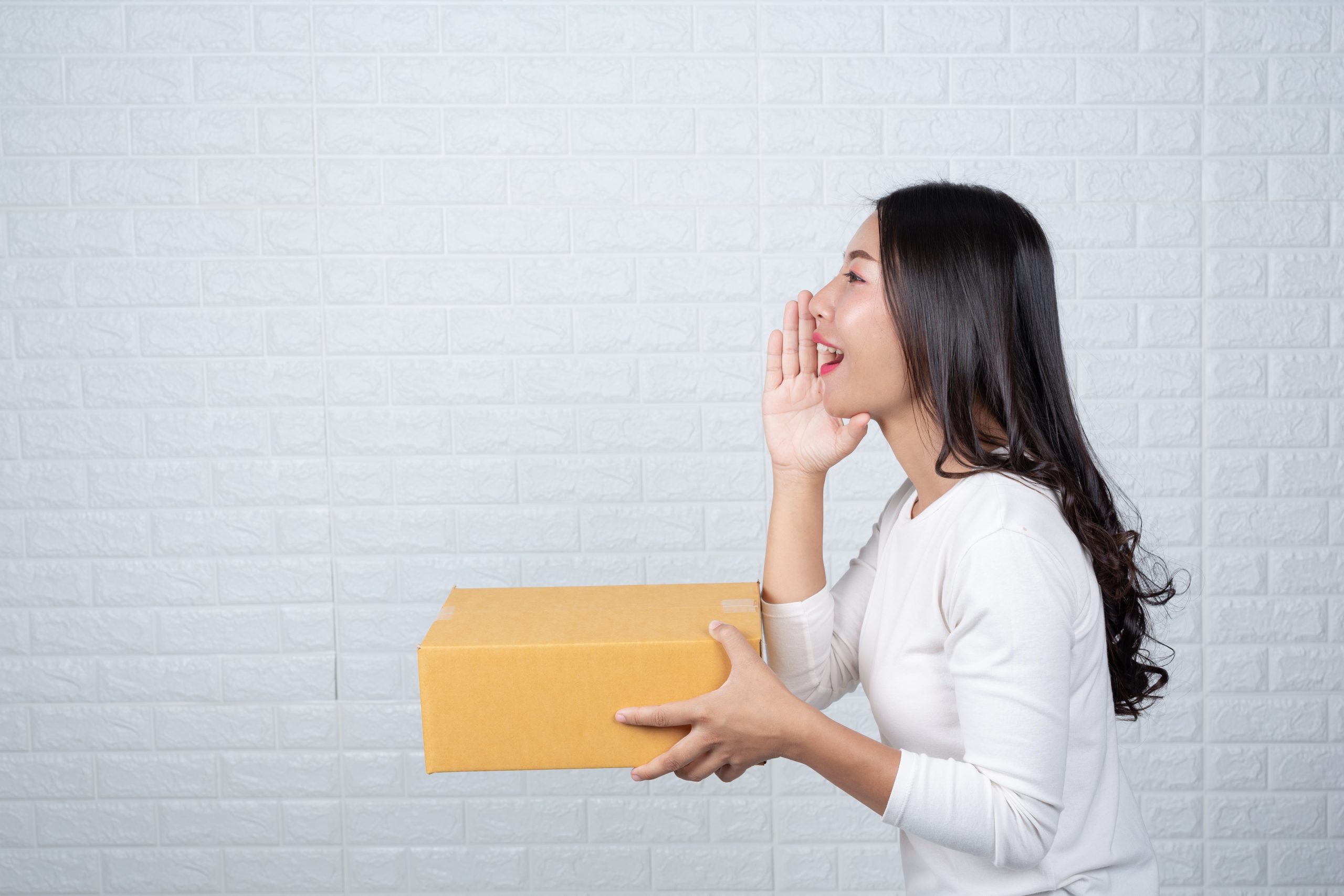 woman holding brown post box made gestures with sign language scaled